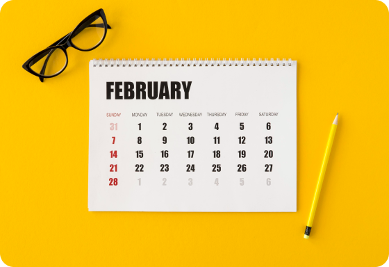 Calendar with pencil and glasses on a yellow background