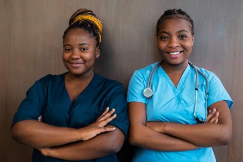 Black female doctor and nurse with arms folded and smiling