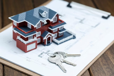 A miniature house with keys on a clipboard