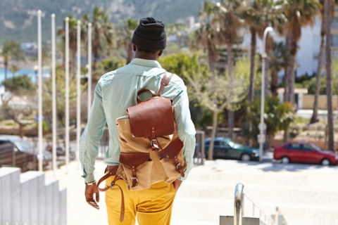 Man with Orange pants and a brown bag walking